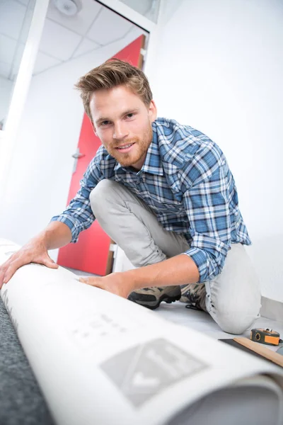 Teppichleger rollt den alten Teppich aus — Stockfoto