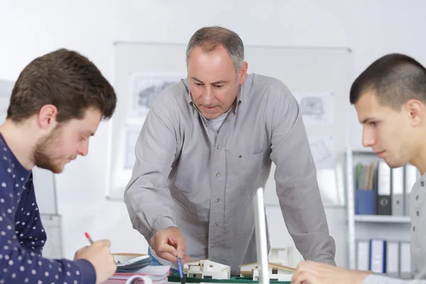 Professeur avec deux étudiants architectes — Photo