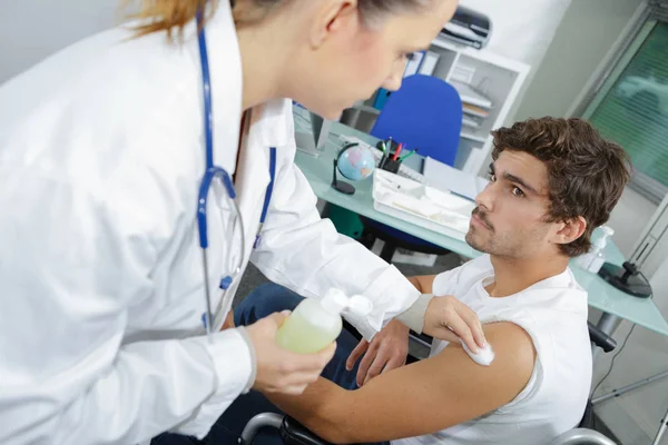 Junge Ärztin bereitet einer jungen Patientin eine Spritze vor — Stockfoto