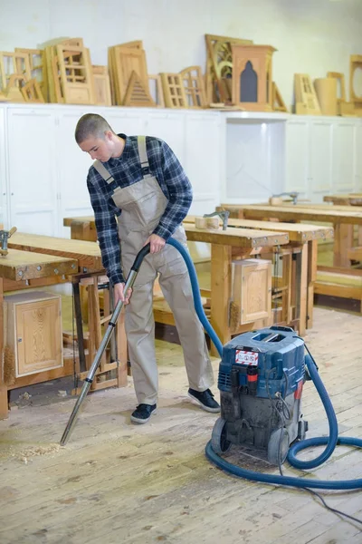 Carpenter cleaning the floor — Stock Photo, Image