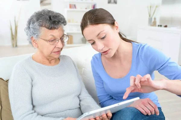 Moeder en dochter met tablet pc zittend op de Bank — Stockfoto