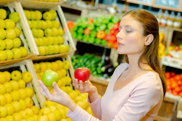 Lady holding äpplen av två olika sorter — Stockfoto