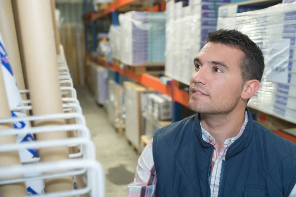 Klusjesman selecteren een zak van product in een magazijn — Stockfoto