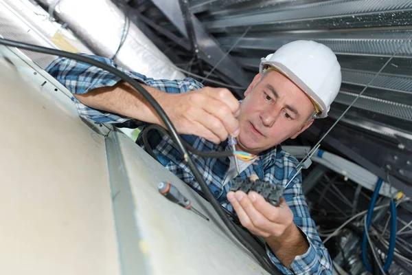 Eletricista fixando luzes no teto — Fotografia de Stock