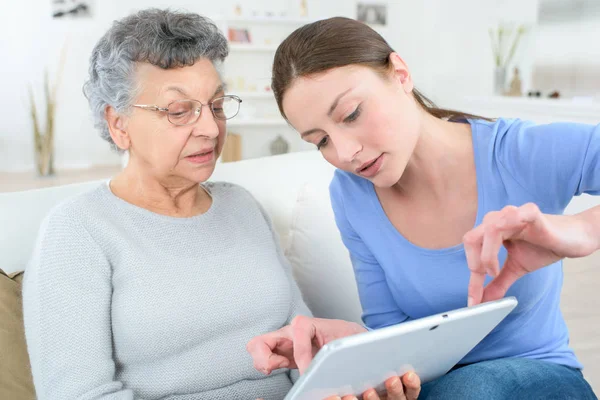 Dospívající vnučky zobrazeno babička jak používat digitální Tablet — Stock fotografie