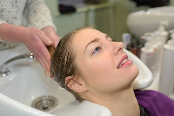 Coiffeur laver les cheveux du client au salon — Photo