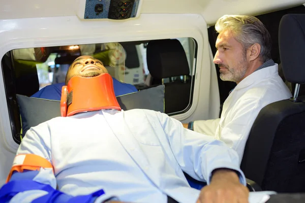 Sanitäter im Krankenwagen begleitet Mann im Nackenbereich — Stockfoto
