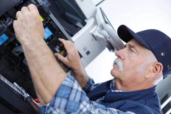 Hombre técnico abriendo fotocopiadora en una oficina —  Fotos de Stock