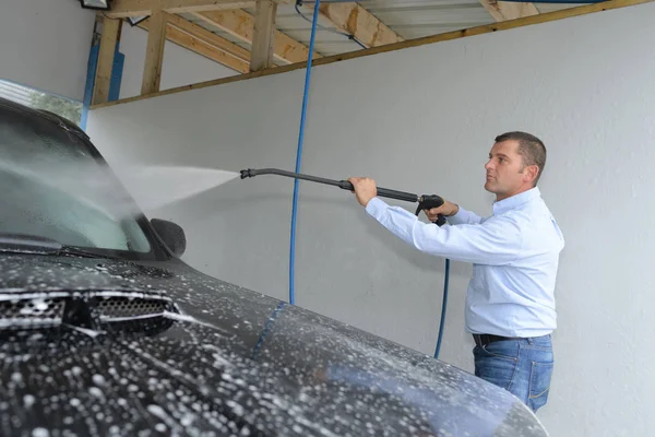 Middelbare leeftijd man zijn auto wassen — Stockfoto