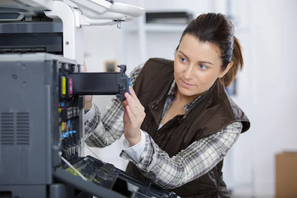 Mujer que fija el cartucho en la máquina de la impresora en oficina —  Fotos de Stock