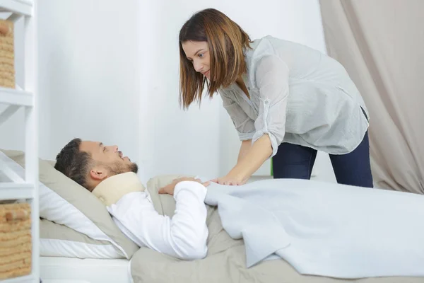 Flickvän hand tar om man sjuk i på sängen — Stockfoto