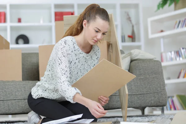 Frau montiert Möbel zu Hause auf dem Fußboden — Stockfoto