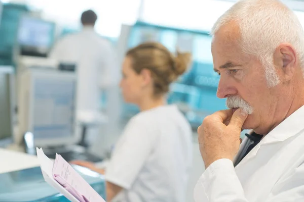Manlig medicine doktor läsa dokument på Urklipp — Stockfoto