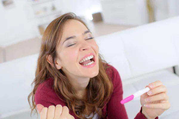 Lycklig kvinna som håller graviditetstest — Stockfoto