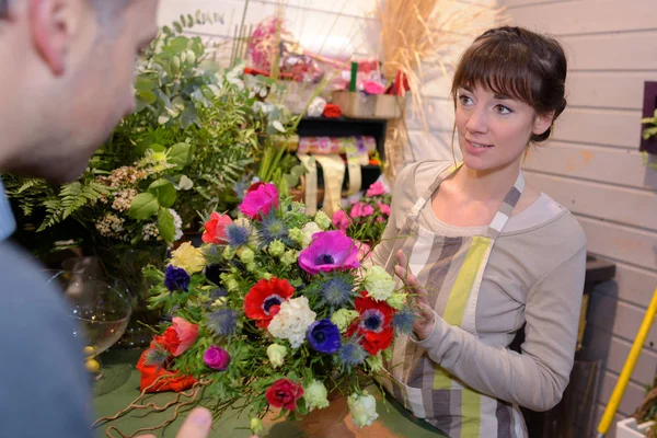 Floristería femenina trabajando en la sección de flores en la tienda —  Fotos de Stock