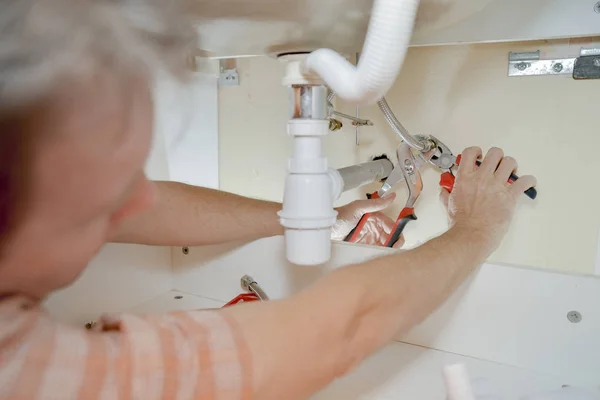 Plumber under the sink — Stock Photo, Image