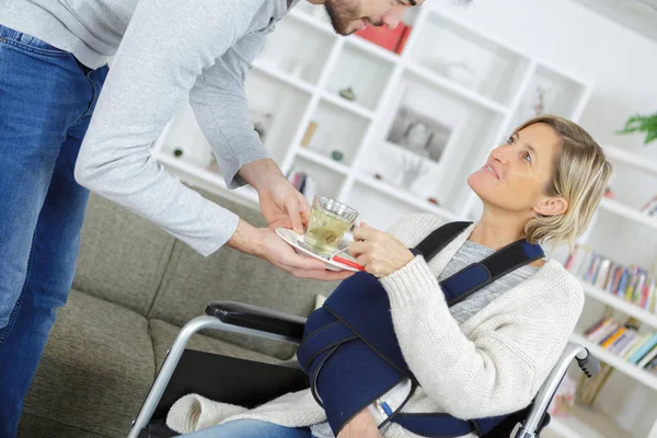 Mannelijke verzorger helpen oude vrouw in rolstoel — Stockfoto