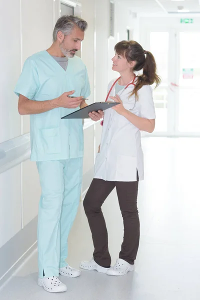 Medico e infermiere è in piedi in un corridoio ospedaliero — Foto Stock