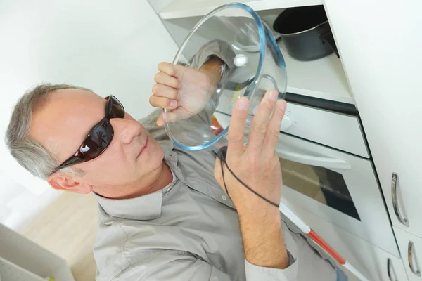 Mature blind man taking a bowl in the kitchen — Stock Photo, Image