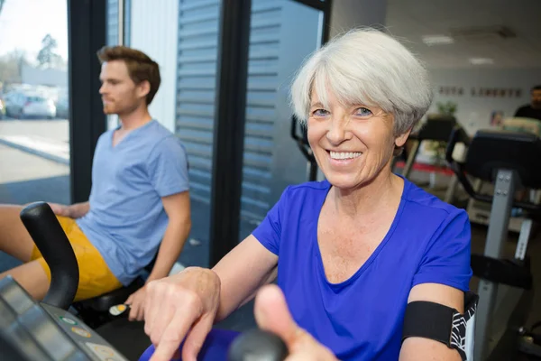 Усміхнена жінка старший вправа в спортзалі — стокове фото