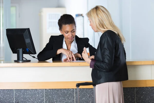 Cliente falando com o receocionista de um hotel — Fotografia de Stock