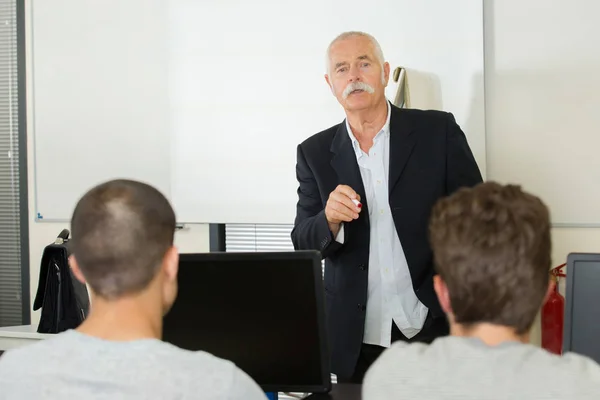 Group of students with professor in modern school classroom — Stock Photo, Image