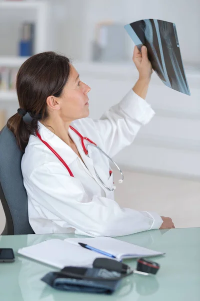 Γυναίκα γιατρός εξετάζει μια ακτινογραφία των ασθενών — Φωτογραφία Αρχείου