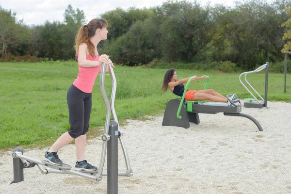 야외 체육관에서 스포츠 기계에 운동 하는 여자 — 스톡 사진