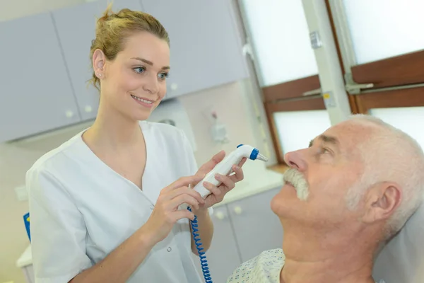 Paciente sênior reparando dente na clínica odontológica — Fotografia de Stock