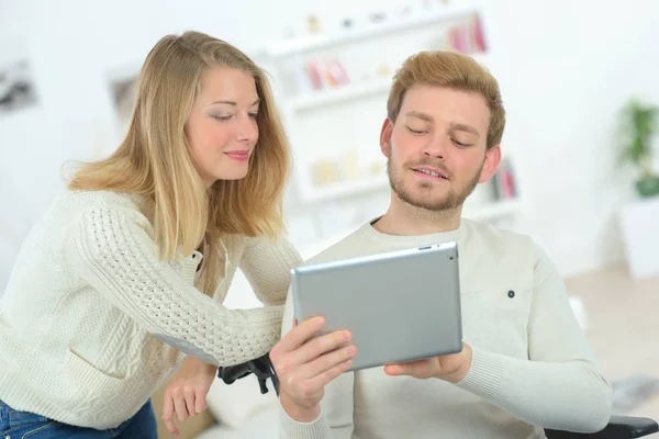 Jovem casal usando um tablet dentro de casa — Fotografia de Stock