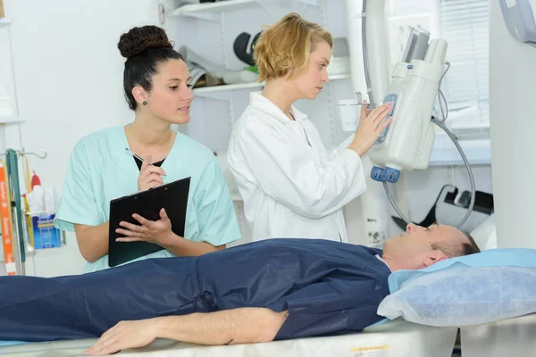 Medico guardando paziente femminile passando attraverso CT Scansione — Foto Stock