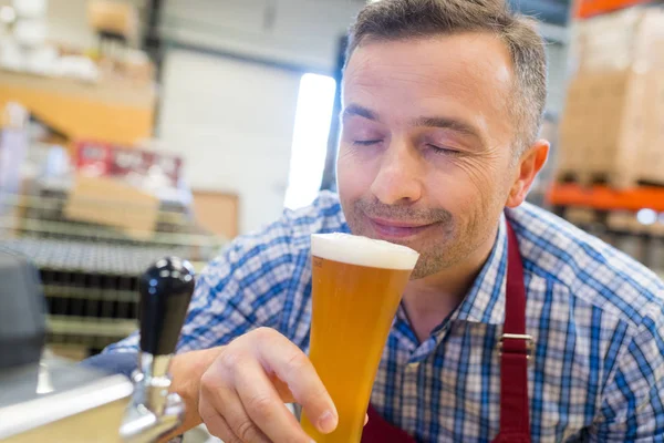 Close-up van Brouwer ruiken biertje in brouwerij fabriek — Stockfoto