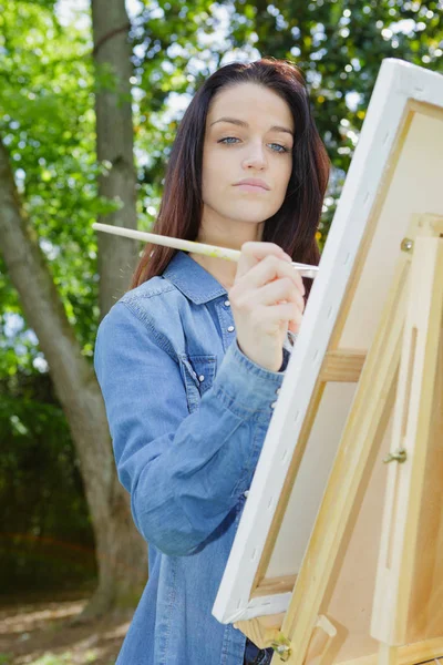 Young lovely caucasian woman painting outdoors — Stock Photo, Image