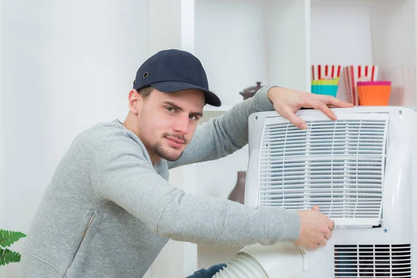 Knappe technicus installeren airconditioners in gebouw — Stockfoto