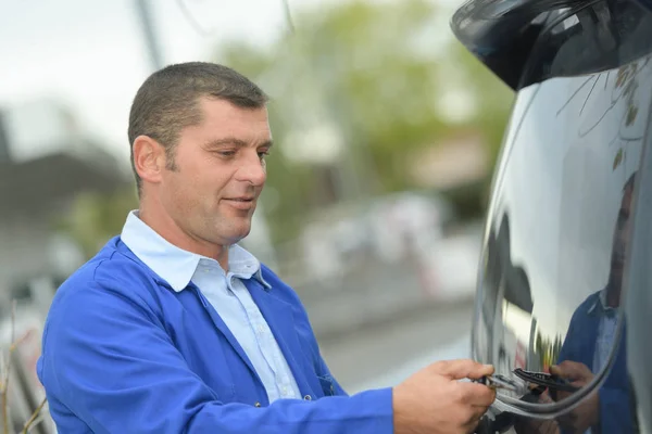 Middle age man polishing a car in the garage — Stock Photo, Image