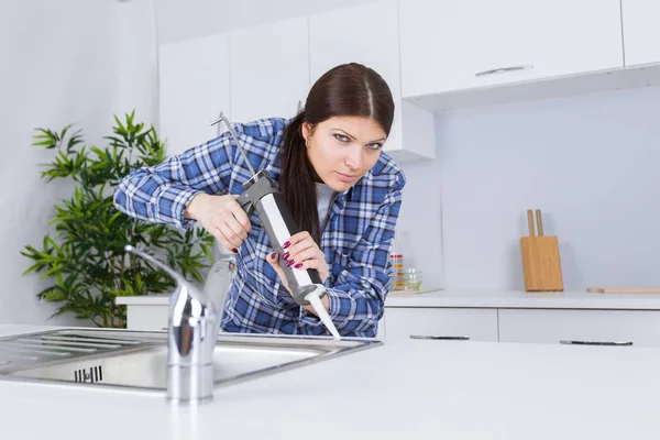 Technikerin kesselt Waschbecken mit Silikonkleber ab — Stockfoto