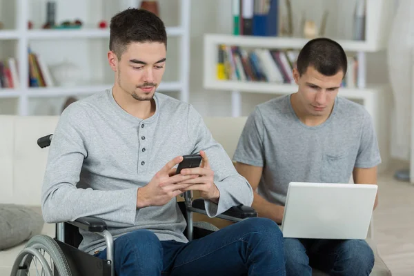 Junge Männer mit Technik, einer im Rollstuhl — Stockfoto