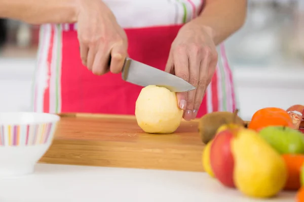 Close-up em mãos maduras femininas cortando maçãs na tábua de corte — Fotografia de Stock