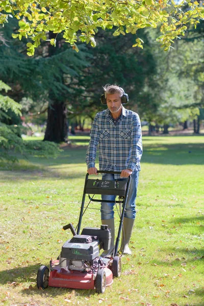 Homem cortando grama e homem — Fotografia de Stock