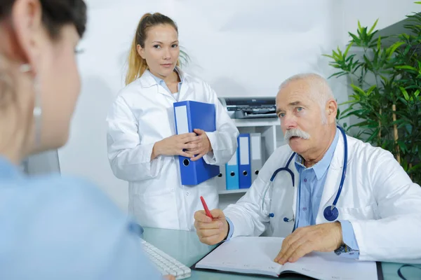 Arzt hört einem Patienten in seinem Büro zu — Stockfoto