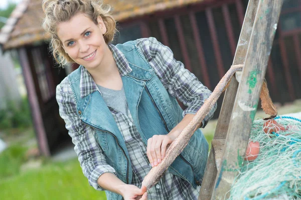 Boerderij van de jonge vrouw die zich voordeed en leunend op de ladder — Stockfoto