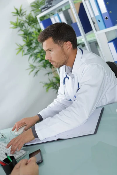 Médico trabalhando à mesa no escritório — Fotografia de Stock