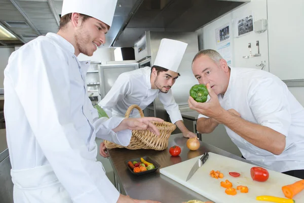Chef cuisinier repas avec des apprentis Photo De Stock