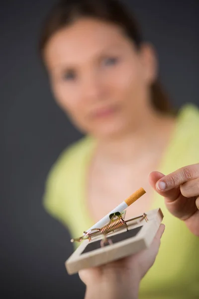 Kobieta sięgnąć po papierosa na pułapka na myszy — Zdjęcie stockowe