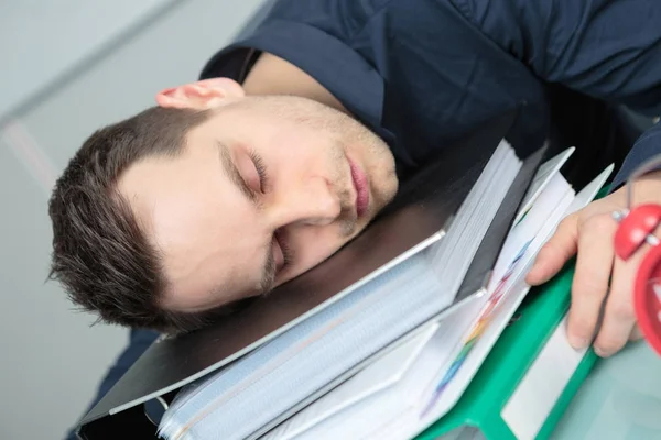 Man sover på stacken av mappar — Stockfoto