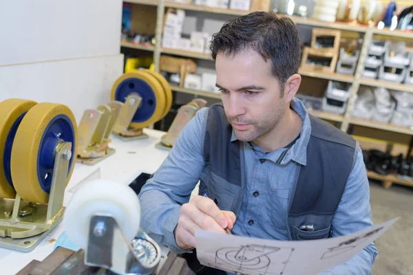 Man putting together a transport trolley — Stock Photo, Image