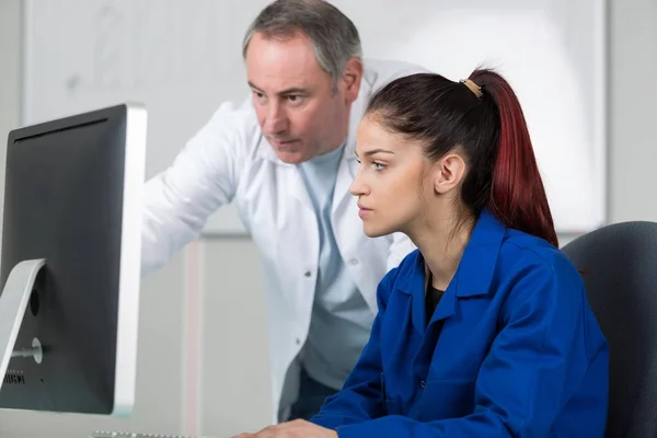 Mechaniker und Lehrling arbeiten am Auto mit Computer — Stockfoto