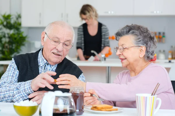 Heureux couple de personnes âgées discutant tout en prenant le petit déjeuner à table — Photo