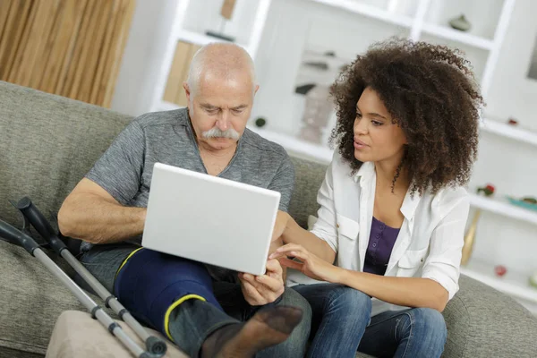 Homem velho ferido usando laptop — Fotografia de Stock