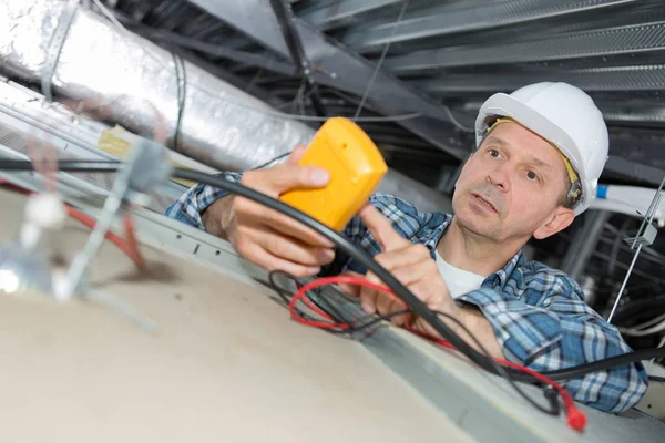 Électricien réparer le câblage dans un bureau — Photo